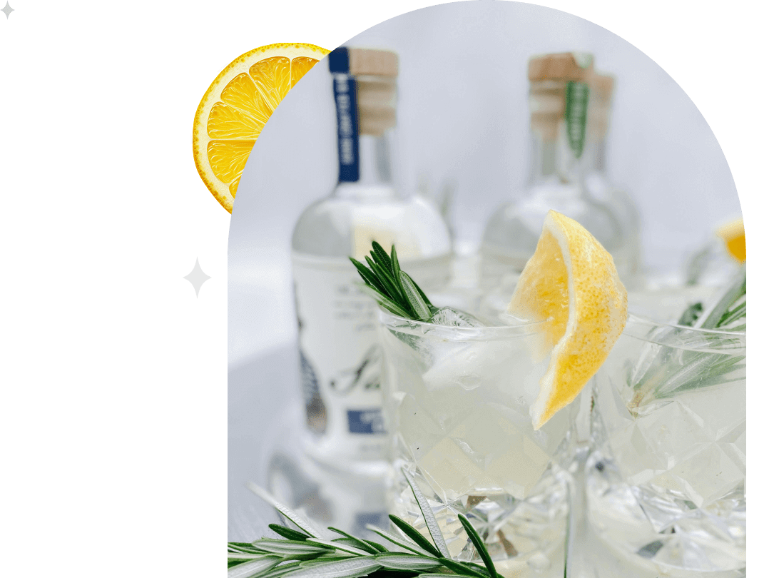 Refreshing lemon and rosemary cocktails with clear bottles in the background.